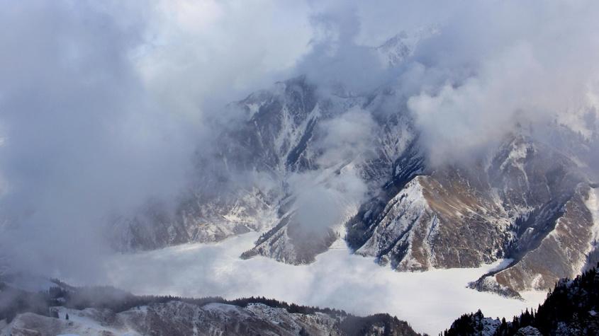 雪后新疆天山天池云雾缭绕引游人